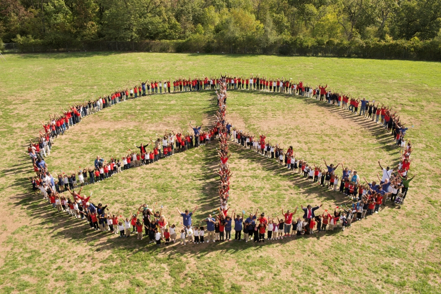 Peace on earth people standing outside in formation of a peace sign